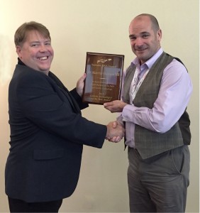 Brad Larkin presents the 2015 Genetic Genealogist of the Year Award plaque to Dr Maurice Gleeson MB